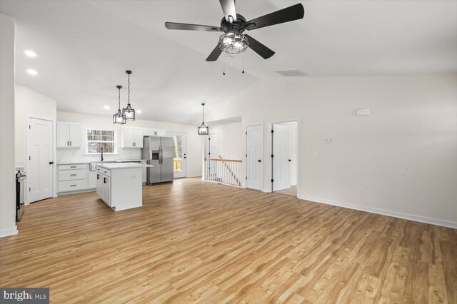 kitchen featuring white cabinetry, sink, hanging light fixtures, a center island, and stainless steel fridge with ice dispenser