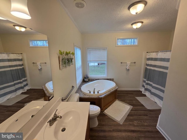 full bathroom featuring a healthy amount of sunlight, wood finished floors, and a textured ceiling