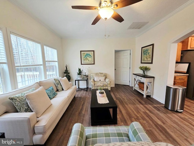 living room with a ceiling fan, baseboards, dark wood-type flooring, and crown molding