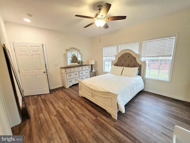 bedroom featuring dark wood-style floors, a ceiling fan, and baseboards