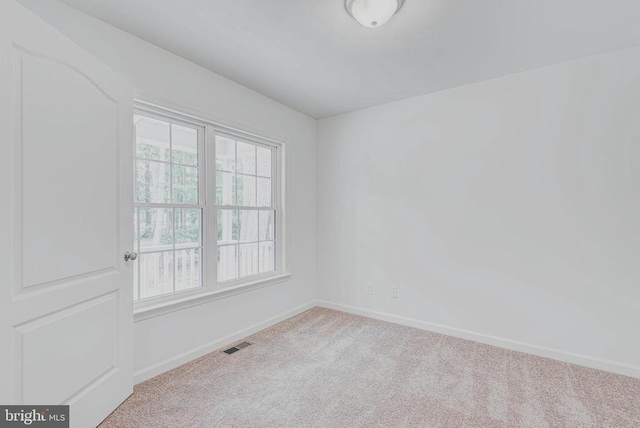 carpeted spare room with baseboards and visible vents