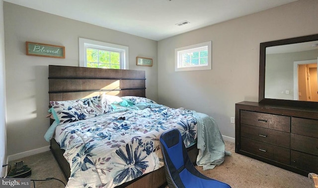 carpeted bedroom with baseboards, visible vents, and multiple windows