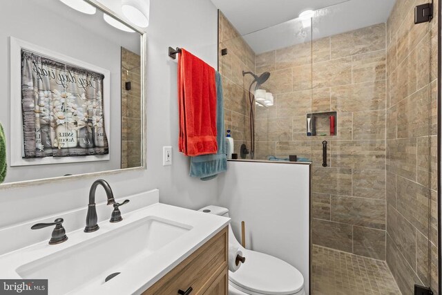 bathroom with vanity, a shower with shower door, and toilet