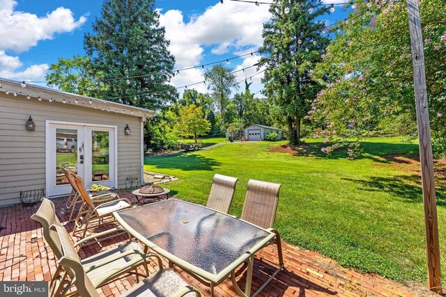 view of patio with french doors, a deck, and a fire pit