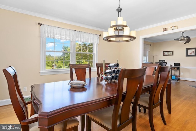 dining space with crown molding, a notable chandelier, and light hardwood / wood-style flooring