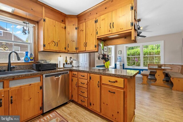 kitchen with dishwasher, sink, kitchen peninsula, and light wood-type flooring