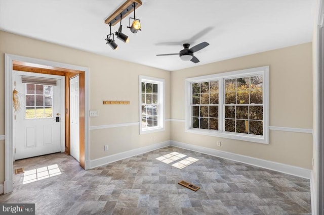 interior space with visible vents, baseboards, and a ceiling fan