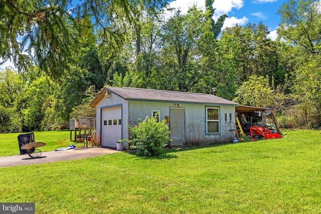 view of outdoor structure featuring a garage, a carport, and a lawn