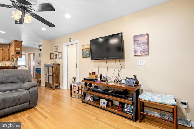 living room with light hardwood / wood-style flooring and ceiling fan