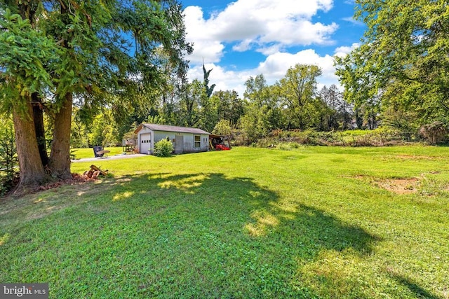 view of yard with a garage and an outbuilding