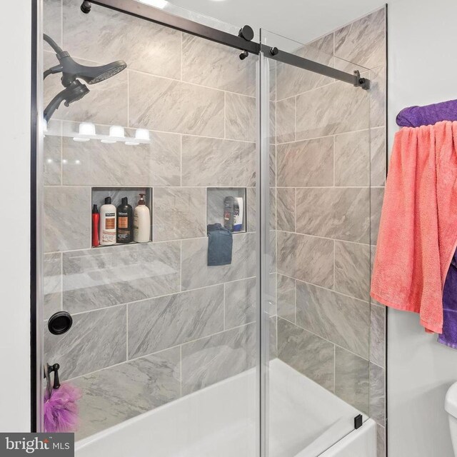 bathroom with combined bath / shower with glass door