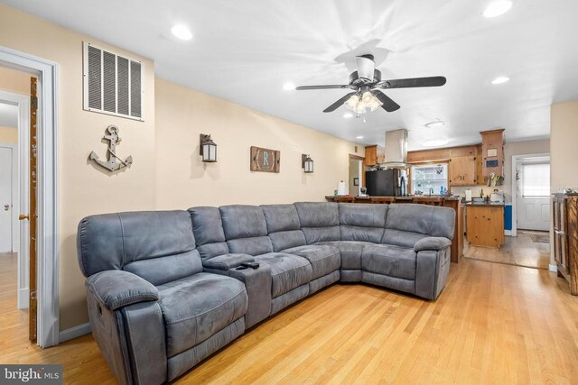 living room with ceiling fan and light hardwood / wood-style floors