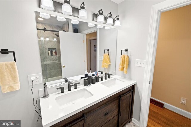 bathroom with vanity, hardwood / wood-style floors, and a shower with shower door