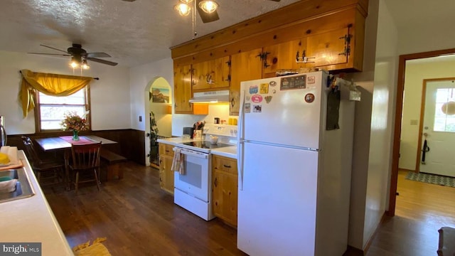 kitchen with light countertops, under cabinet range hood, ceiling fan, and white appliances