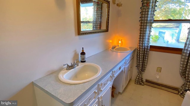 bathroom featuring double vanity, a sink, tile patterned floors, and a baseboard heating unit