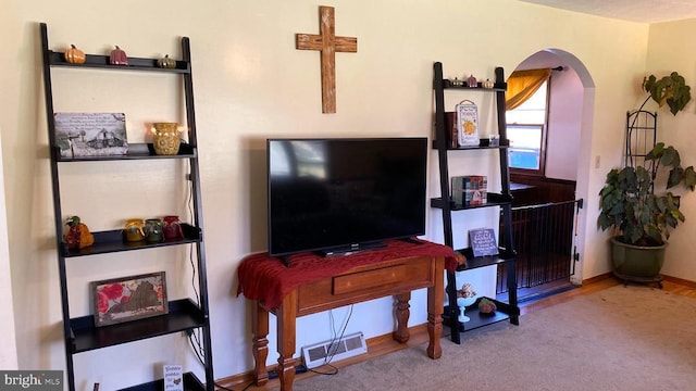living room with visible vents, arched walkways, and carpet