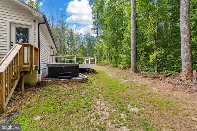 view of yard with a wooden deck and a hot tub