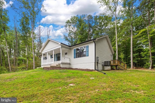 view of front facade with cooling unit, a front yard, and covered porch