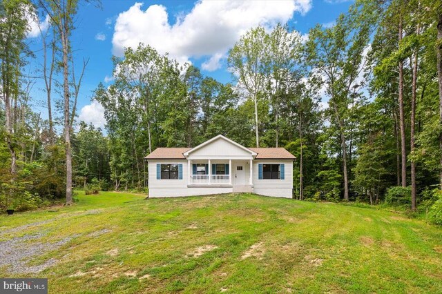 view of front of home with covered porch and a front lawn