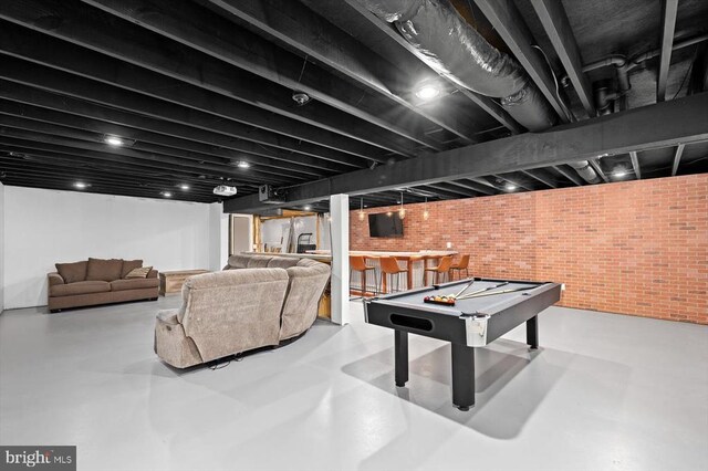 game room featuring indoor bar, brick wall, concrete flooring, and pool table