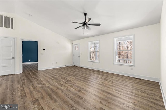 empty room featuring vaulted ceiling, dark wood-type flooring, and ceiling fan