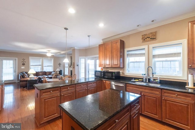 kitchen featuring hanging light fixtures, a kitchen island, sink, and dark stone counters