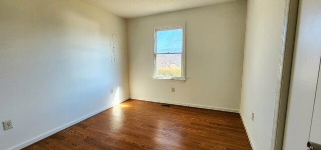 empty room with dark hardwood / wood-style flooring