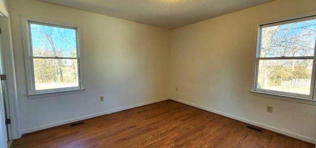 unfurnished room with hardwood / wood-style floors