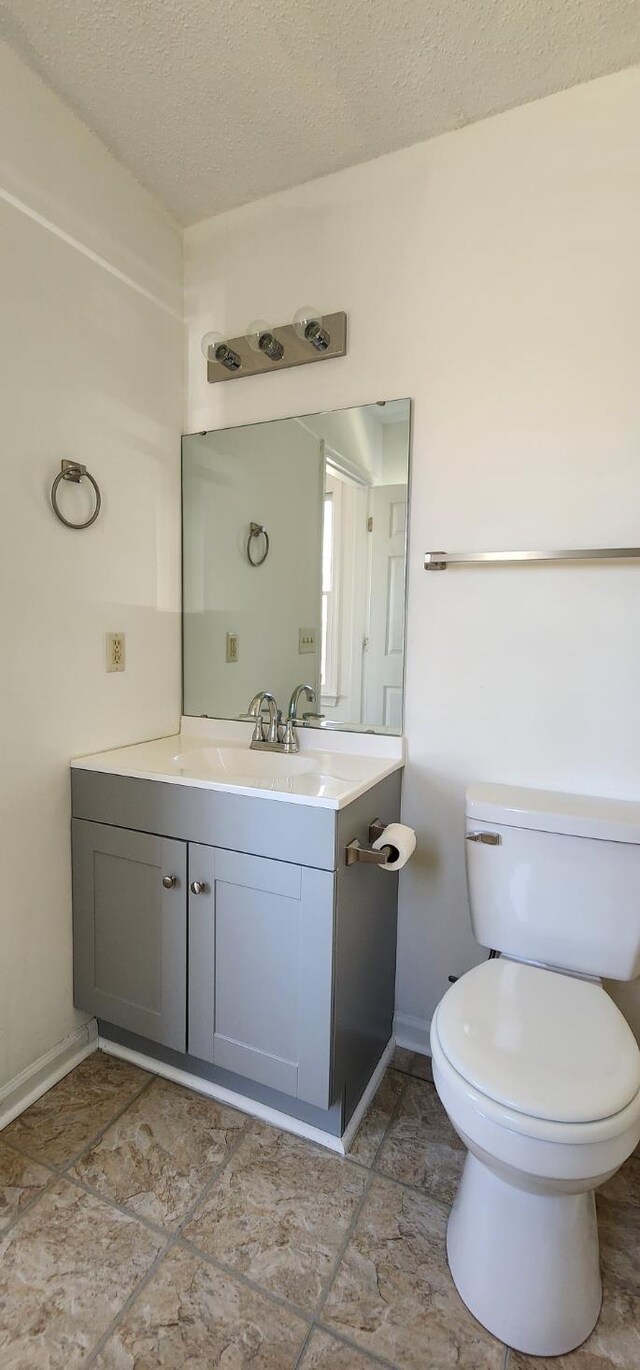 bathroom with vanity, a textured ceiling, and toilet