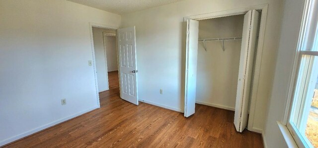 unfurnished bedroom with hardwood / wood-style flooring and a closet