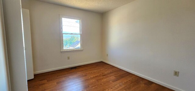 spare room with hardwood / wood-style floors and a textured ceiling