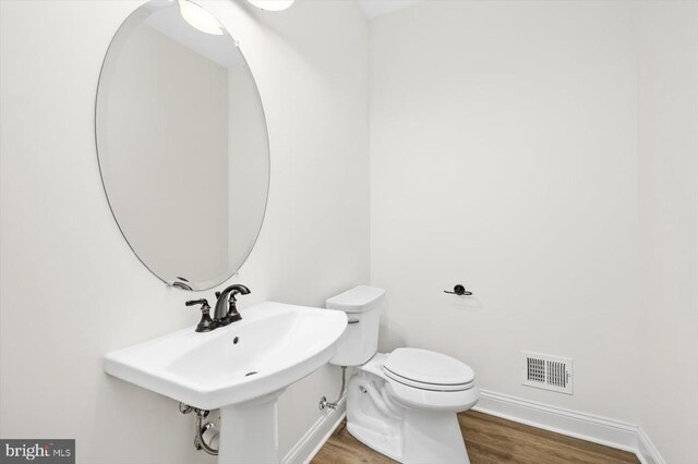 bathroom featuring sink, hardwood / wood-style floors, and toilet