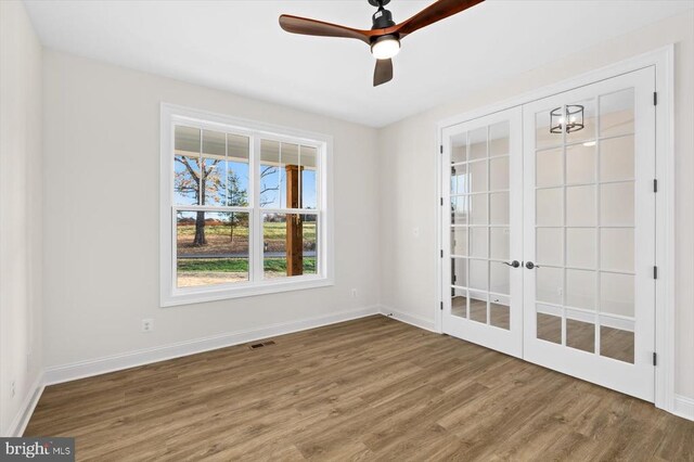 empty room with hardwood / wood-style floors, french doors, and ceiling fan