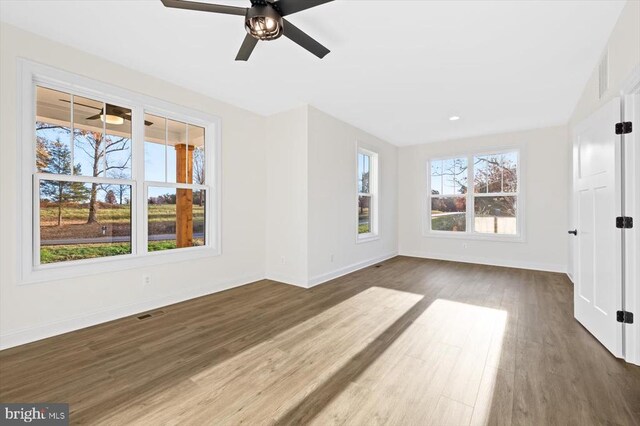 unfurnished room with dark hardwood / wood-style flooring and ceiling fan