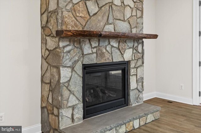 details with hardwood / wood-style flooring and a fireplace