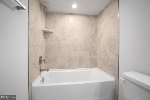 bathroom with tiled shower / bath and toilet