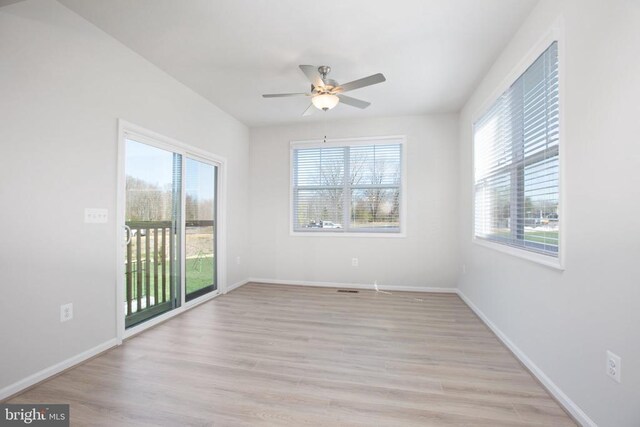 unfurnished room featuring a wealth of natural light, ceiling fan, and light hardwood / wood-style flooring