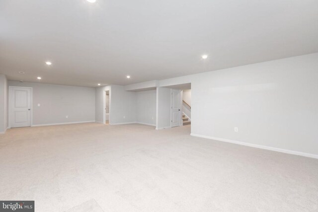 basement featuring light carpet