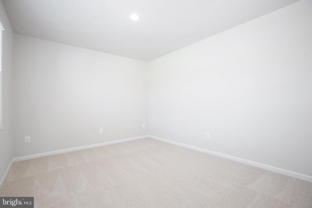 unfurnished room featuring light carpet