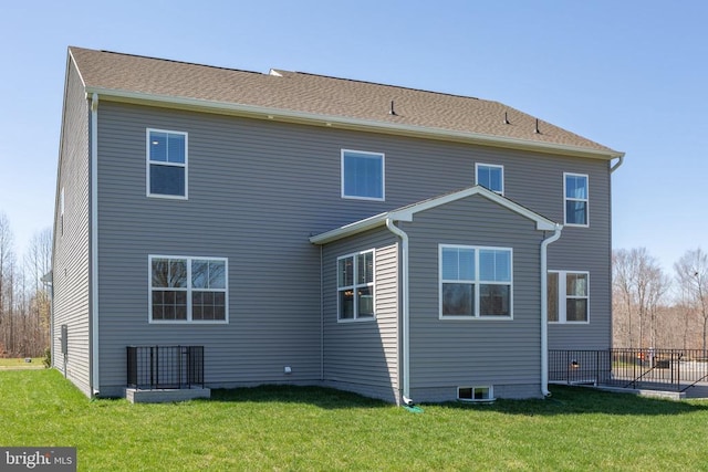 rear view of house featuring a yard