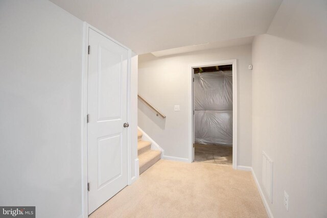 hallway featuring light colored carpet