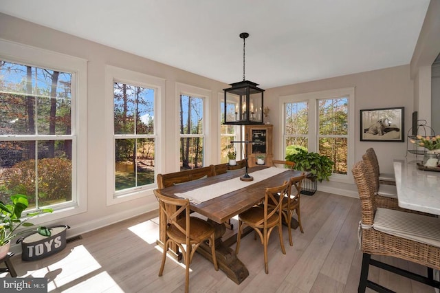dining area with baseboards and light wood finished floors