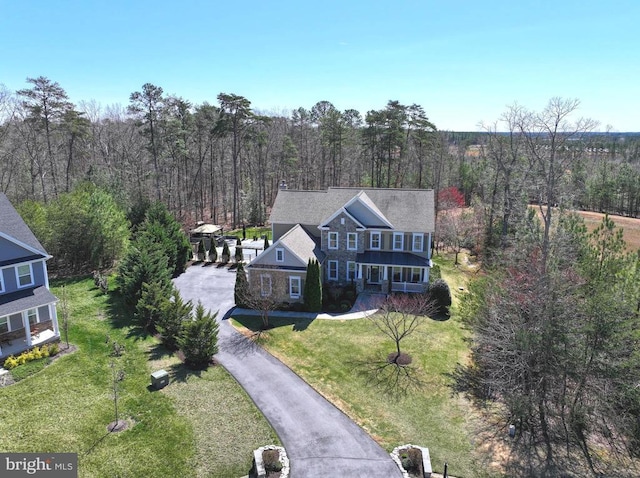 drone / aerial view featuring a wooded view