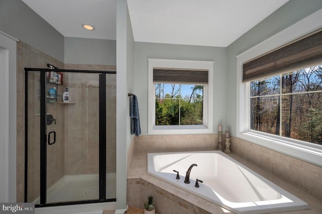 full bathroom with a bath, plenty of natural light, and a shower stall