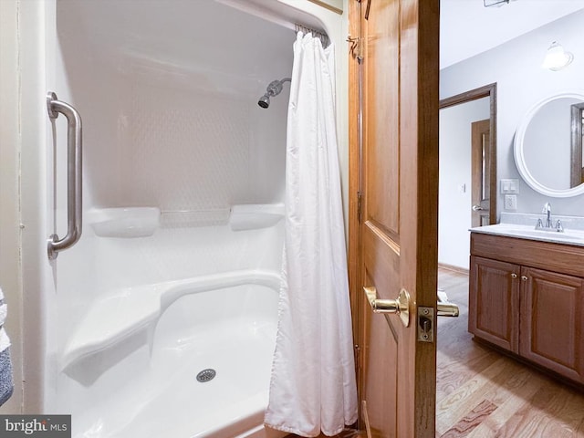 full bathroom with curtained shower, wood finished floors, and vanity