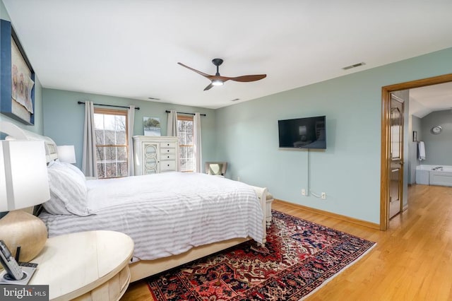 bedroom featuring a ceiling fan, baseboards, visible vents, and wood finished floors