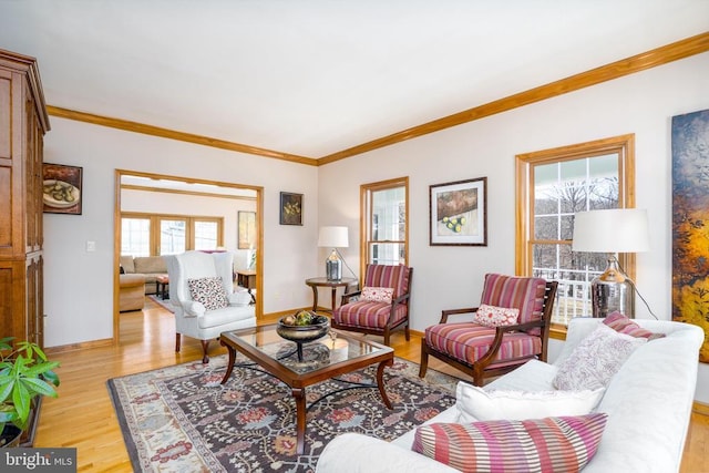 living area with light wood-style floors, crown molding, and baseboards