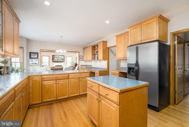 kitchen featuring open shelves, light wood finished floors, a kitchen island, and stainless steel fridge