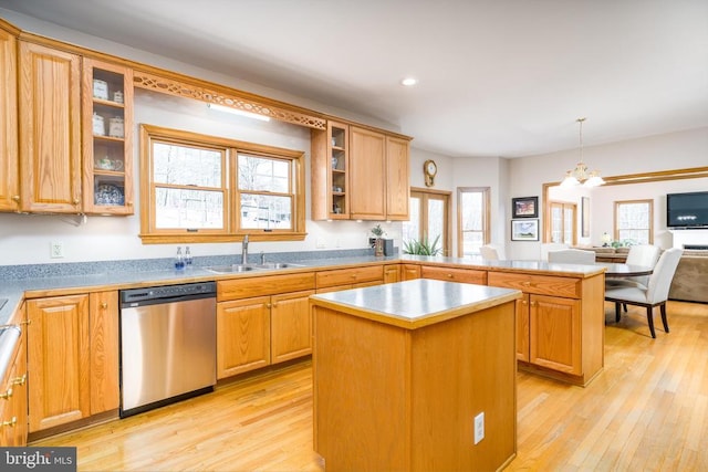 kitchen featuring a sink, light wood finished floors, dishwasher, and a center island