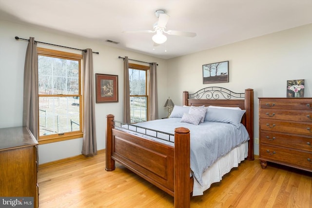 bedroom featuring light wood-style flooring, visible vents, and a ceiling fan